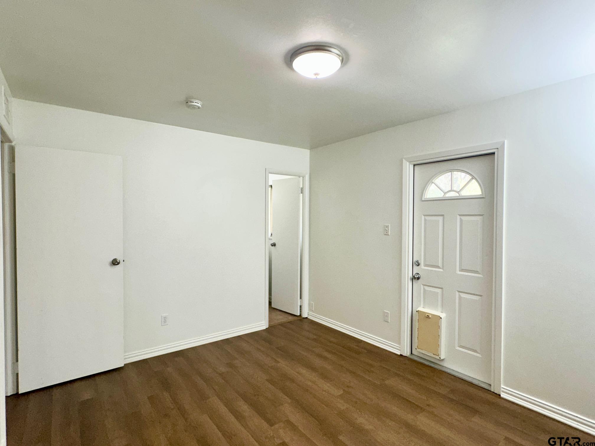2412 East Devine Street Tyler, TX 75701 - Photo 19 of 27 an empty room with wooden floor and windows