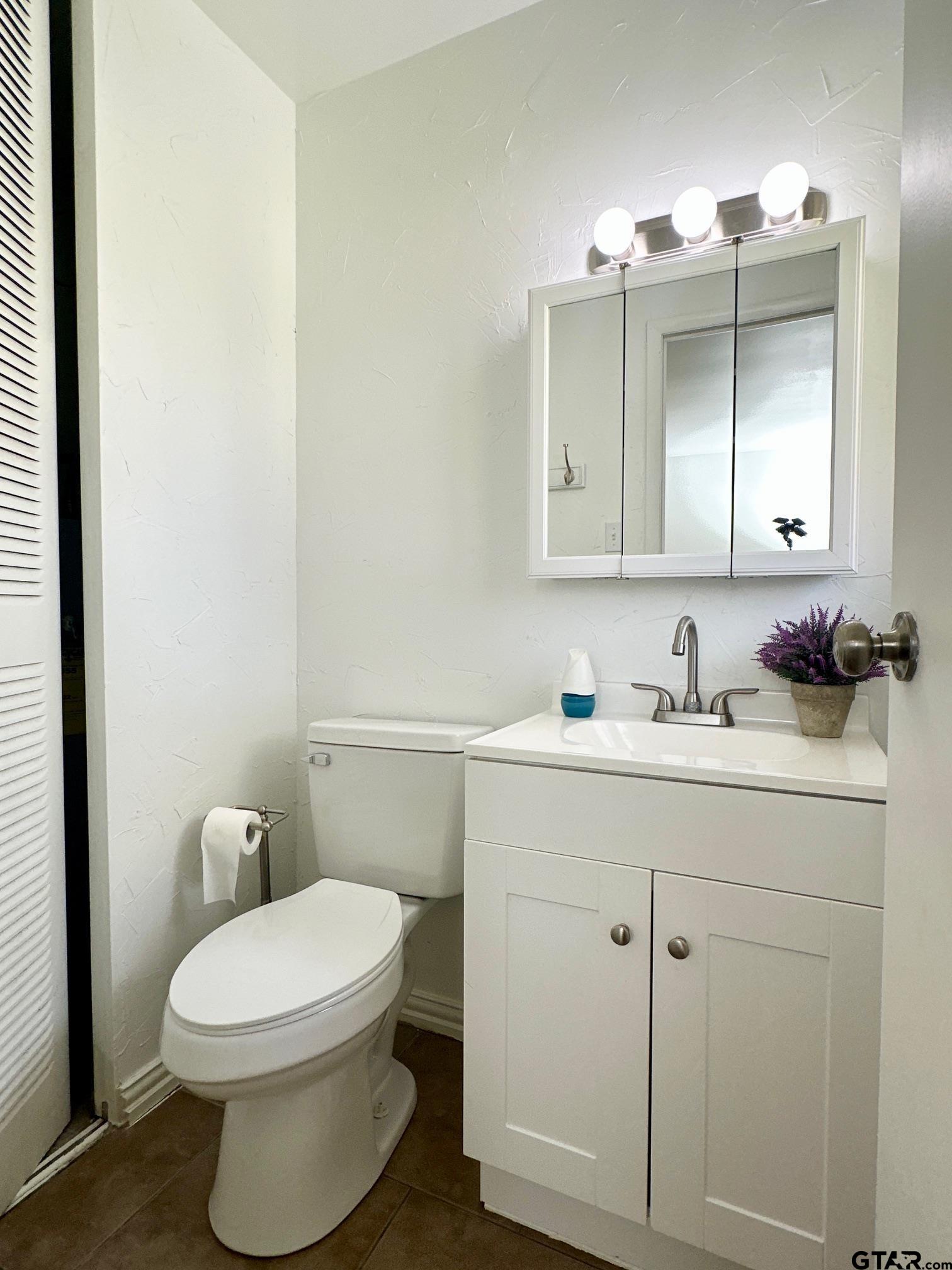 2412 East Devine Street Tyler, TX 75701 - Photo 21 of 27 a bathroom with a toilet sink and mirror