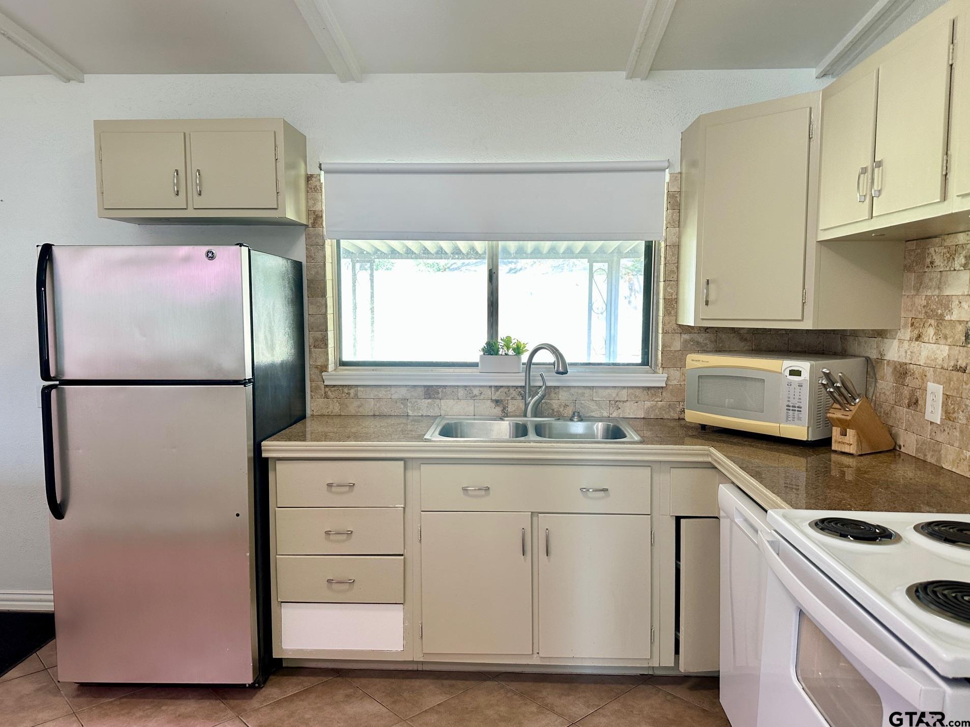 2412 East Devine Street Tyler, TX 75701 - Photo 8 of 27 a kitchen with cabinets appliances a sink and a counter top space
