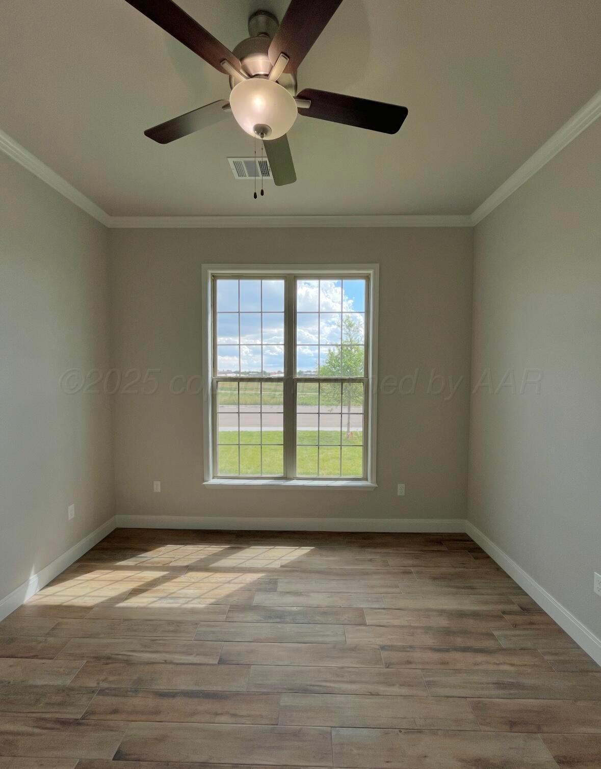 7504 Limestone Drive Amarillo, TX 79119 - Photo 8 of 12 an empty room with wooden floor and windows