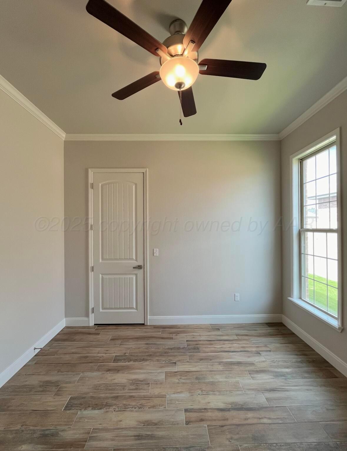 7504 Limestone Drive Amarillo, TX 79119 - Photo 9 of 12 a view of an empty room with window and wooden floor