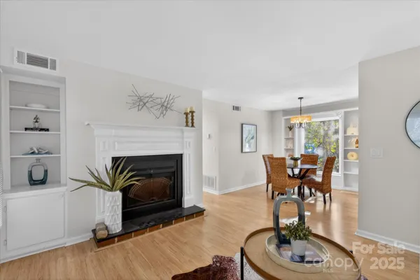 a living room with furniture a fireplace and a large window