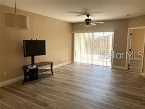a view of a livingroom with a hardwood floor and a ceiling fan