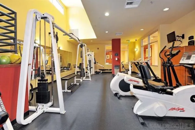 a room with gym equipment and large mirror