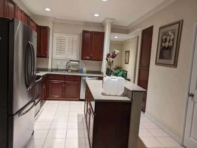 a kitchen with stainless steel appliances granite countertop a sink a refrigerator and a refrigerator