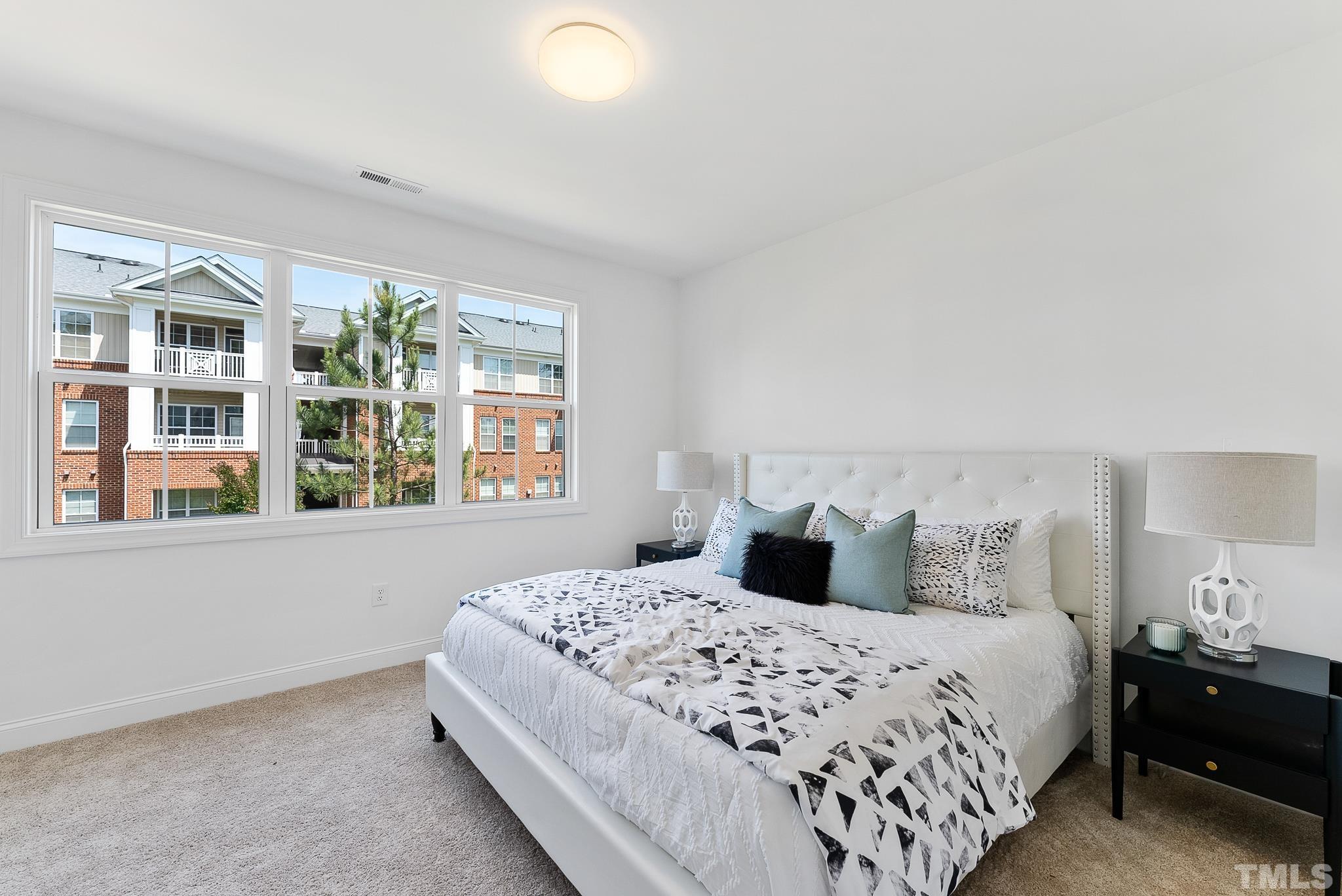 8610 Brushfoot Way, Unit 101 Raleigh, NC 27616 - Photo 17 of 42 a bedroom with a large bed and a large window