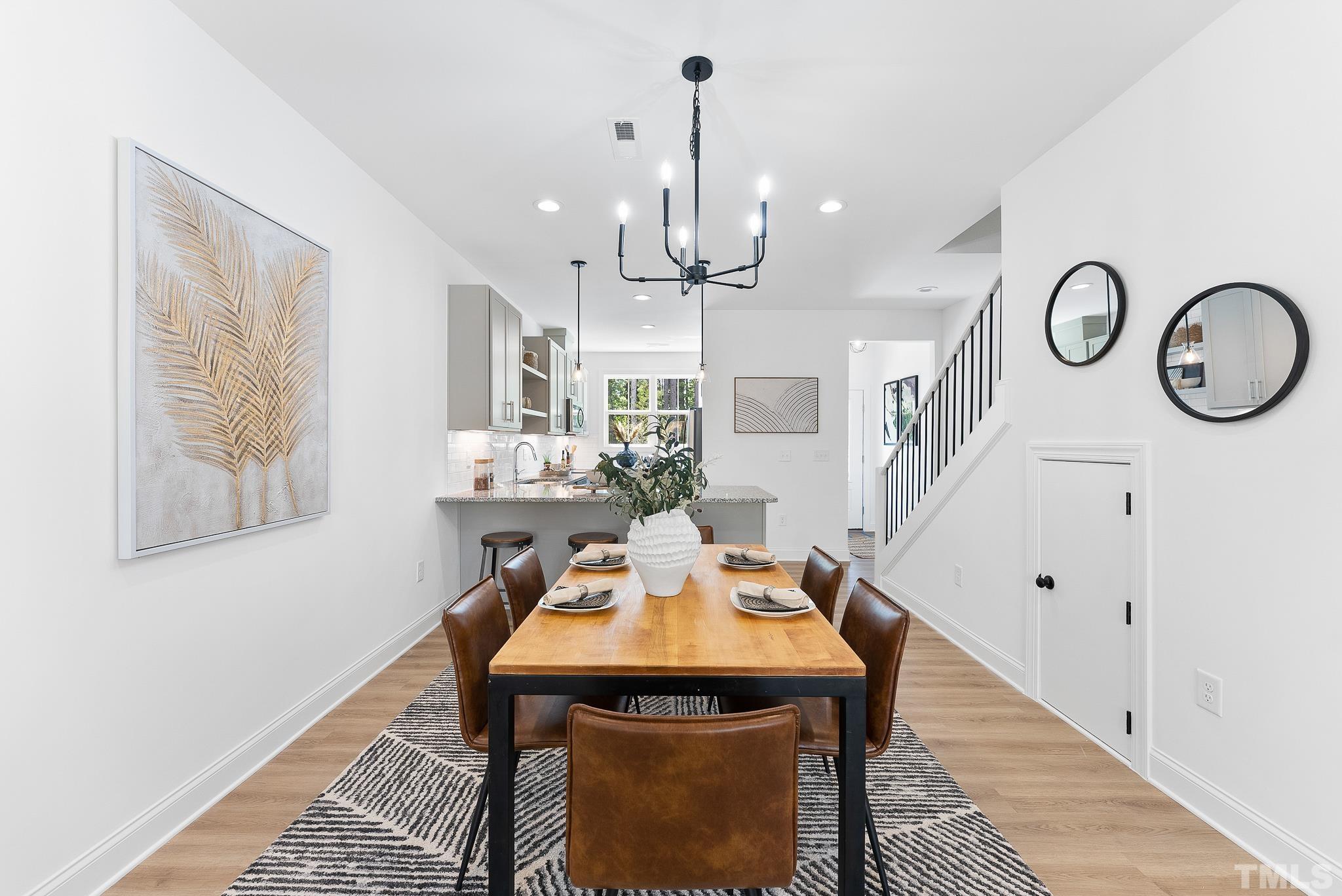 8610 Brushfoot Way, Unit 101 Raleigh, NC 27616 - Photo 9 of 42 a view of a dining room with furniture and a chandelier