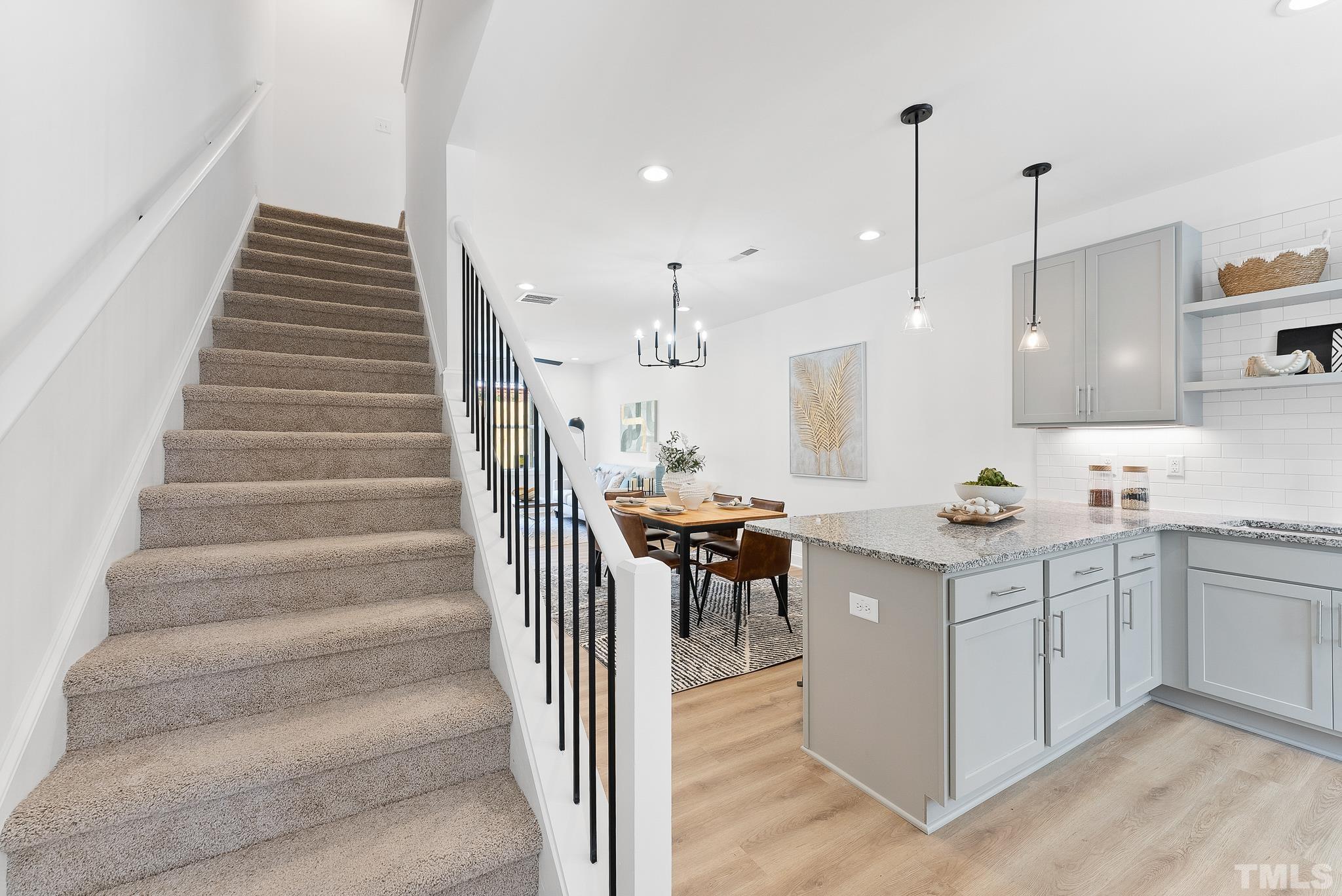 8610 Brushfoot Way, Unit 101 Raleigh, NC 27616 - Photo 10 of 42 a kitchen with a sink a center island and a wooden floor