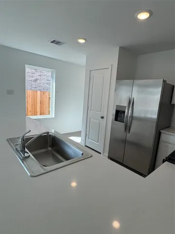 a kitchen with granite countertop a sink and a refrigerator