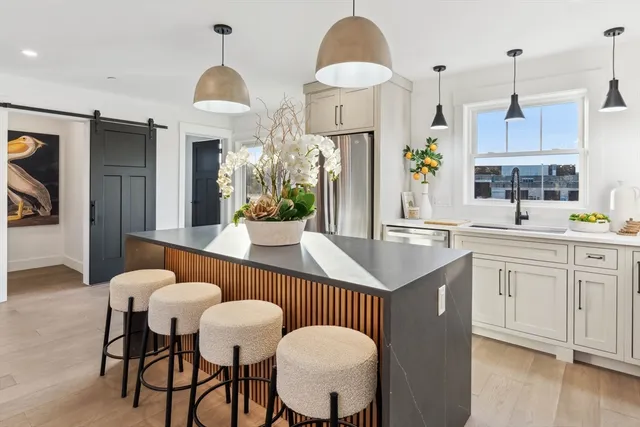 a kitchen with stainless steel appliances a table chairs and a chandelier