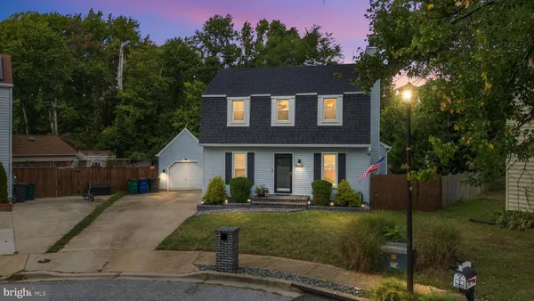 a front view of a house with a yard and trees