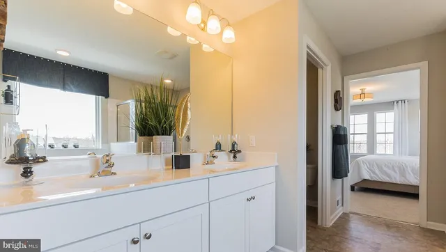 a en suite bathroom with a double vanity sink and a mirror