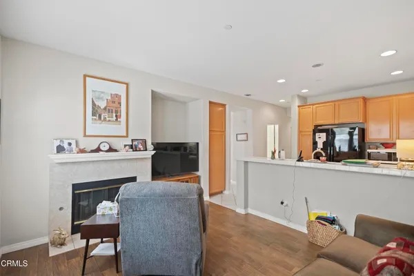 a living room with furniture a fireplace and kitchen view