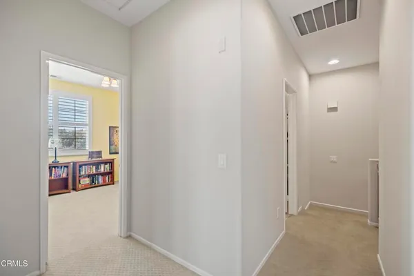 a view of an empty room with large window and a living room