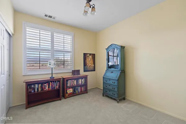 a view of an empty room with window and furniture