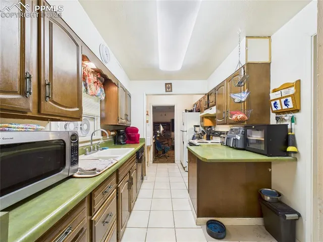 a view of a kitchen with fridge and workspace