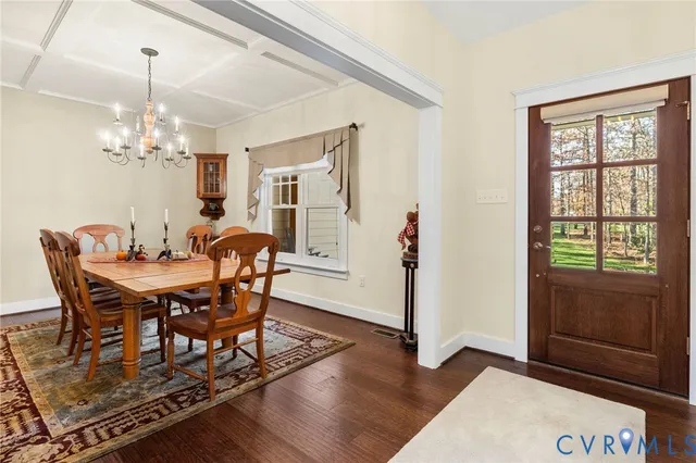 a dining room with furniture a chandelier and wooden floor