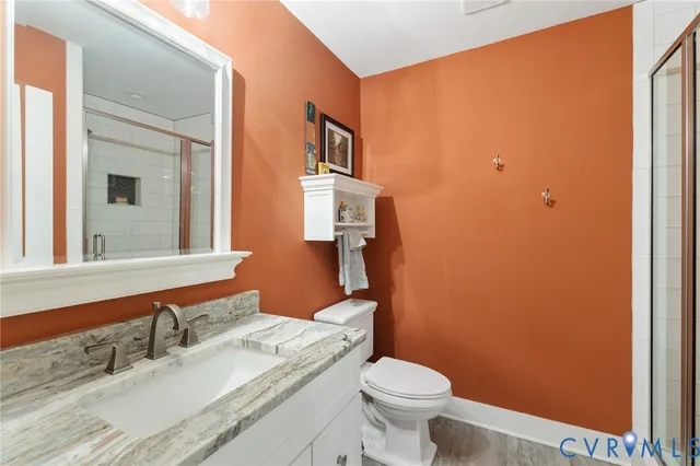 a bathroom with a granite countertop sink toilet and mirror