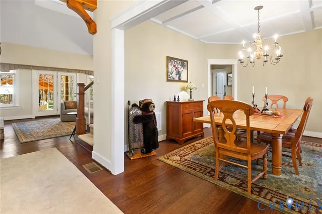 a view of a dining room with furniture a chandelier and wooden floor