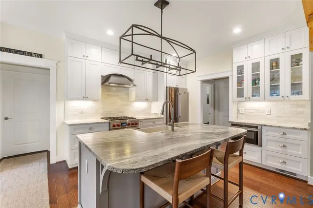 a kitchen with a table chairs cabinets and wooden floor