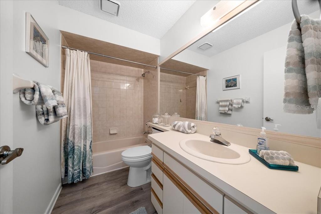 2925 North Rivers Edge Boulevard, Unit 2925 Crystal River, FL 34429 - Photo 11 of 79 a bathroom with a granite countertop sink a toilet a mirror and shower