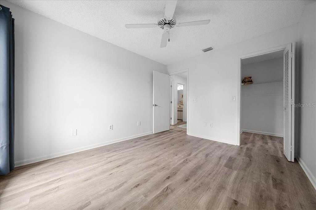 2925 North Rivers Edge Boulevard, Unit 2925 Crystal River, FL 34429 - Photo 17 of 79 an empty room with wooden floor ceiling fan and windows
