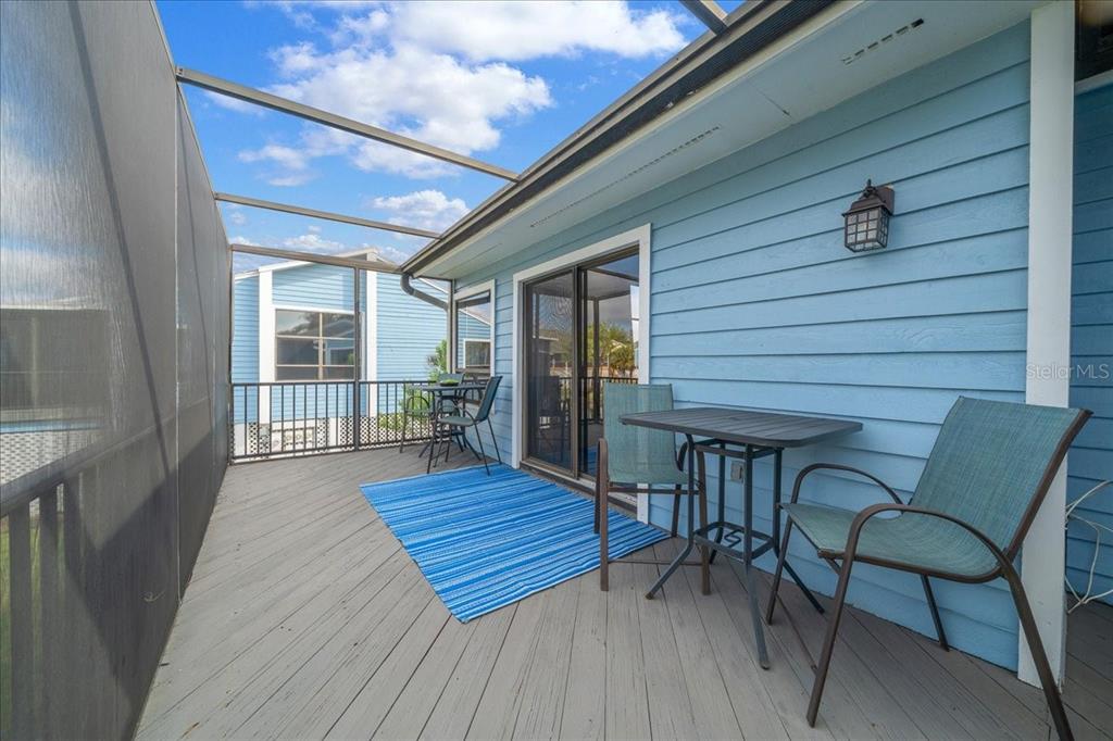 2925 North Rivers Edge Boulevard, Unit 2925 Crystal River, FL 34429 - Photo 21 of 79 a view of a patio with table and chairs with wooden floor and fence