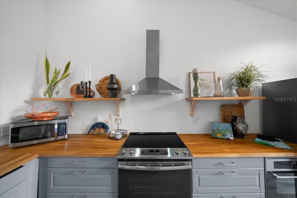 2925 North Rivers Edge Boulevard, Unit 2925 Crystal River, FL 34429 - Photo 66 of 79 a kitchen with stainless steel appliances granite countertop a sink a stove and wooden cabinets
