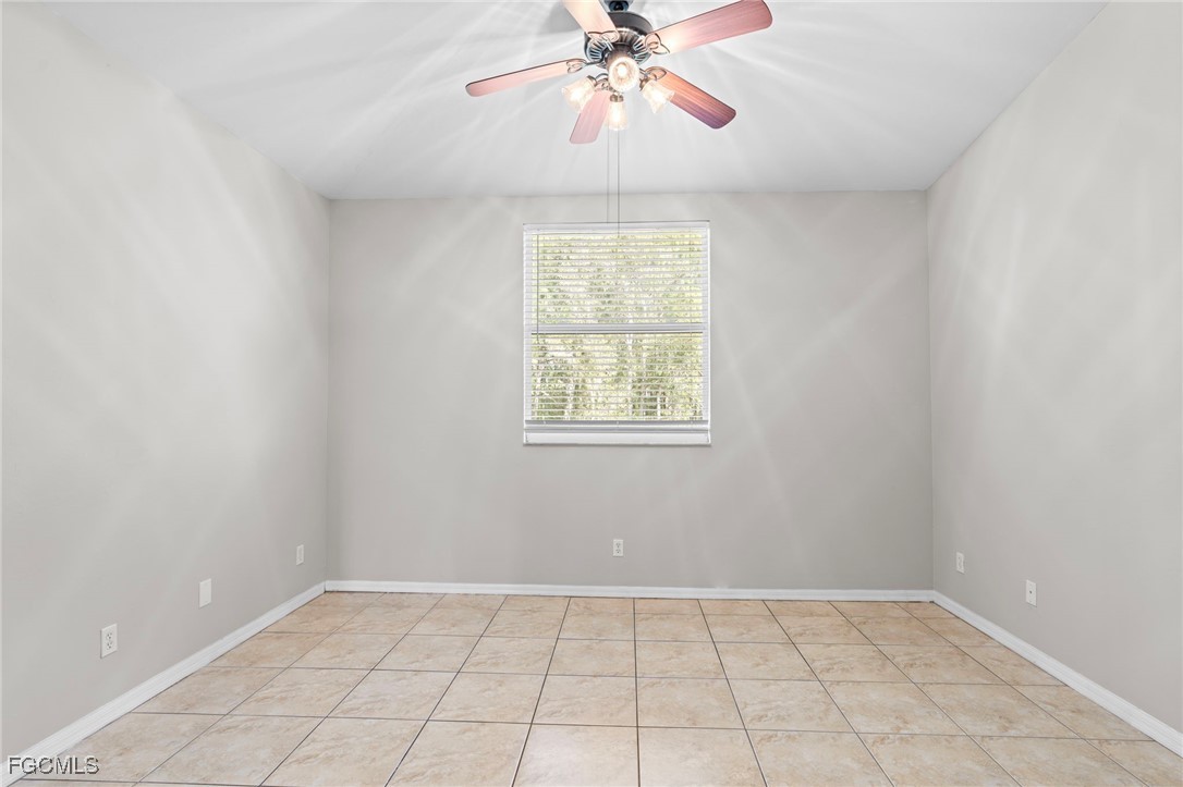 4191 Bellasol Circle, Unit 521 Fort Myers, FL 33916 - Photo 16 of 22 an empty room with chandelier fan and windows