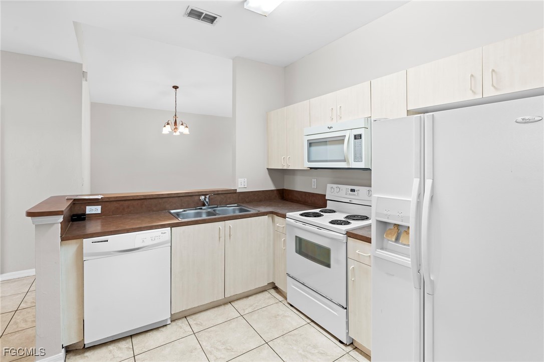 4191 Bellasol Circle, Unit 521 Fort Myers, FL 33916 - Photo 5 of 22 a kitchen with a stove sink and cabinets