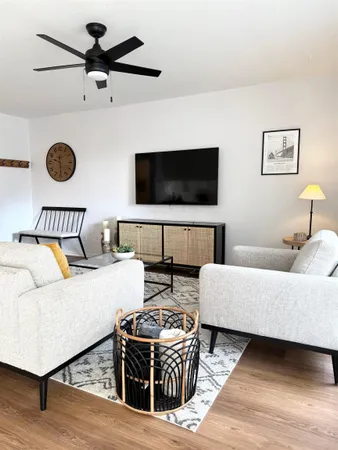 a living room with furniture a flat screen tv and a window