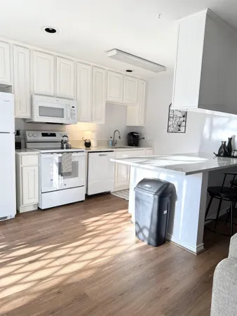 a kitchen with granite countertop a sink cabinets and wooden floor