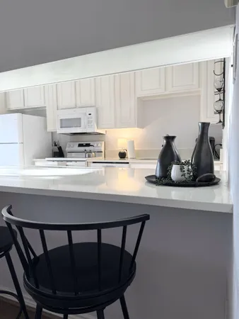 a kitchen with a sink a stove and white cabinets
