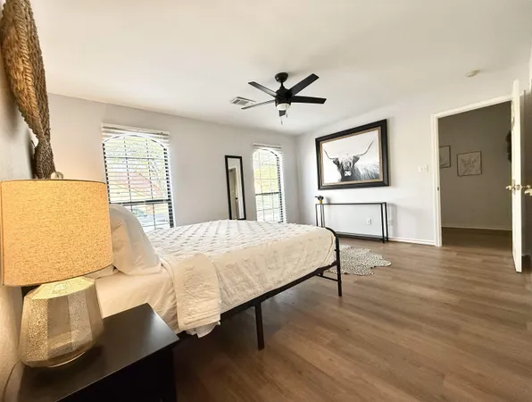 a spacious bedroom with a bed wooden floor and window