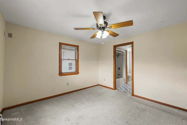 an empty room and chandelier fan