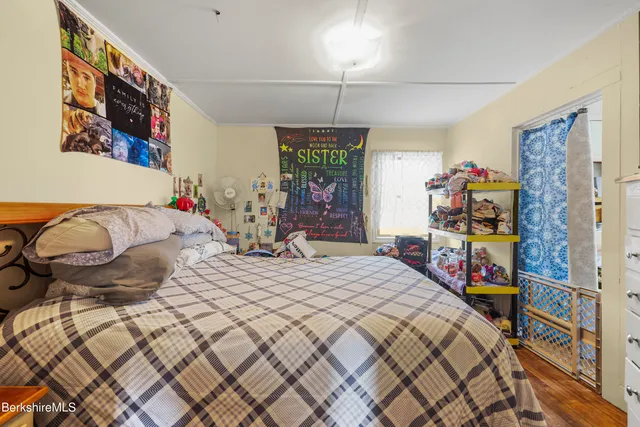 a bedroom with a bed and a flat tv screen on dresser