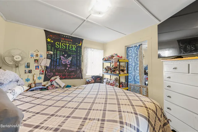 a bedroom with bed and wooden floor