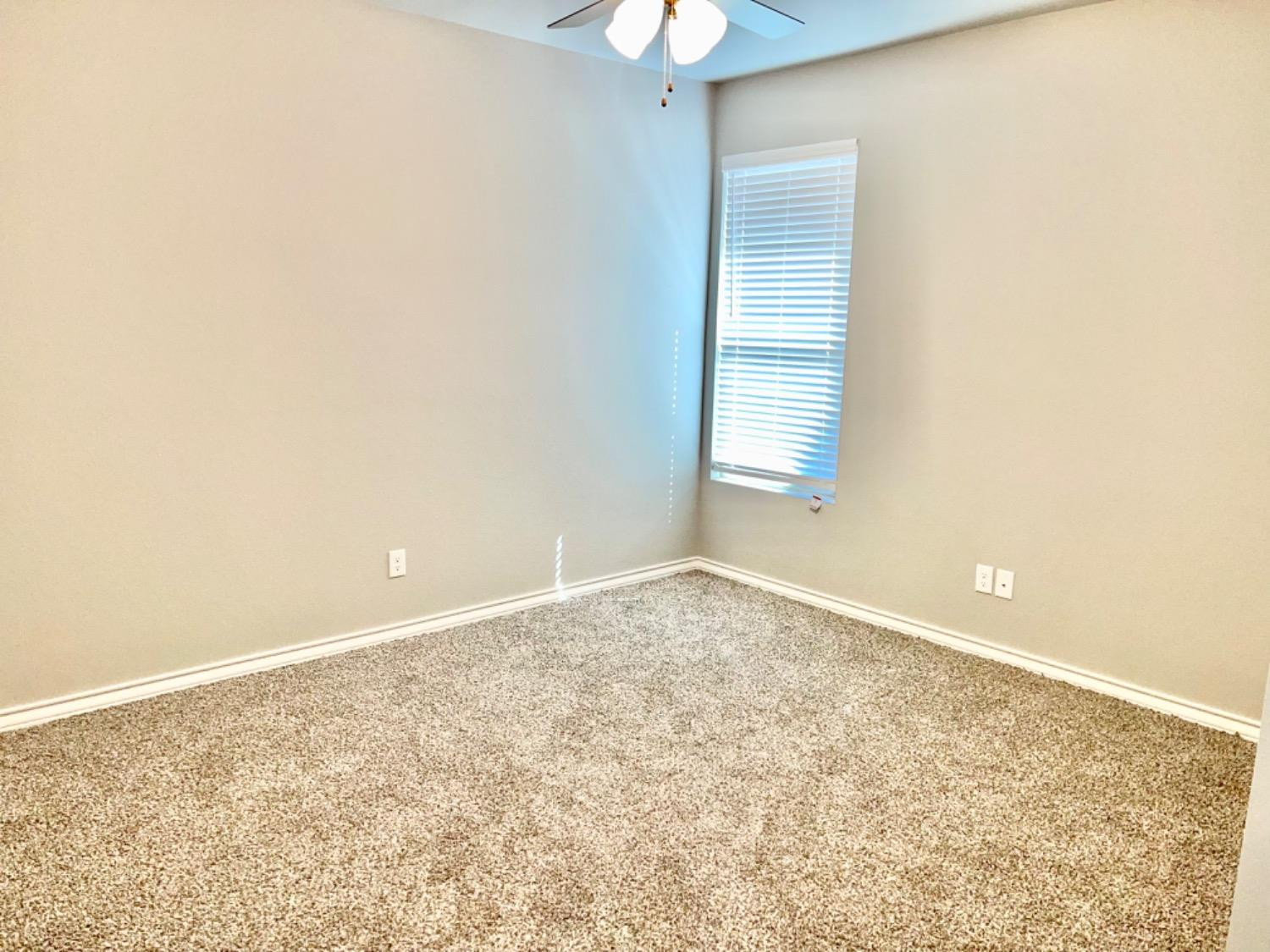 7729 96th Street Lubbock, TX 79424 - Photo 20 of 35 an empty room with a window and a chandelier fan