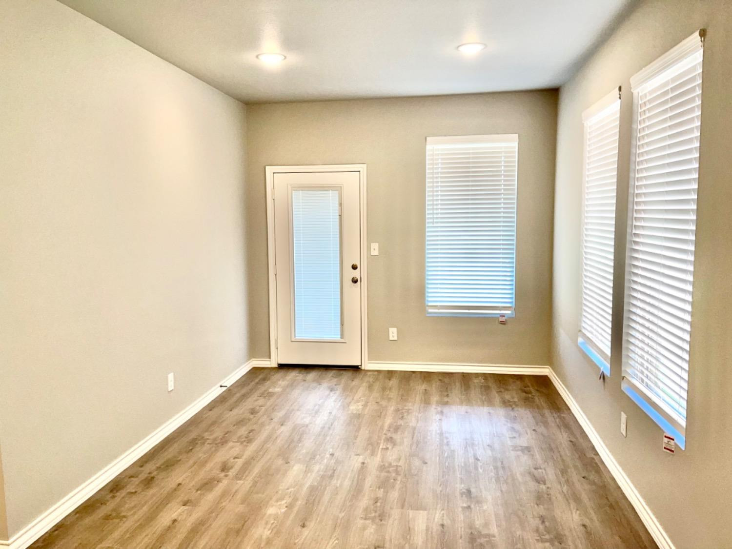 7729 96th Street Lubbock, TX 79424 - Photo 8 of 35 an empty room with wooden floor and windows