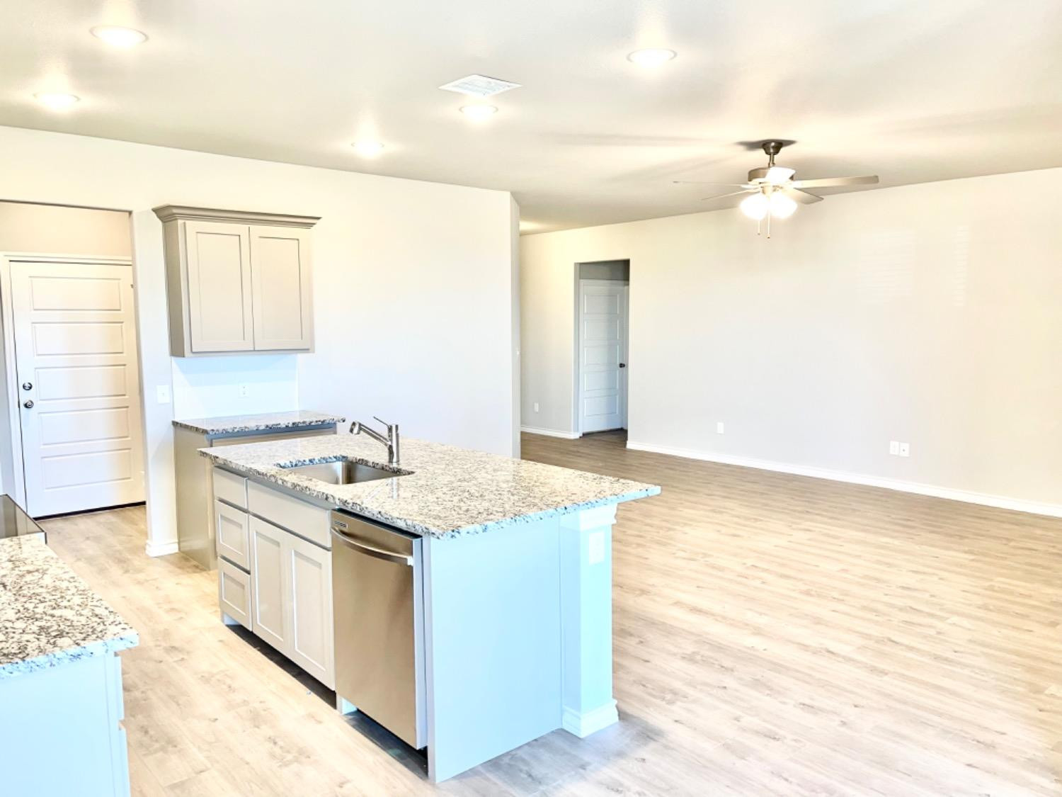 7729 96th Street Lubbock, TX 79424 - Photo 9 of 35 a kitchen with a stove a sink and a refrigerator