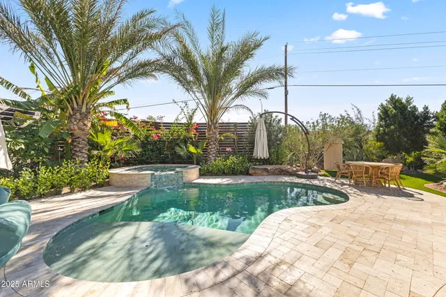 a view of a patio with couches chairs and a fire pit with large trees