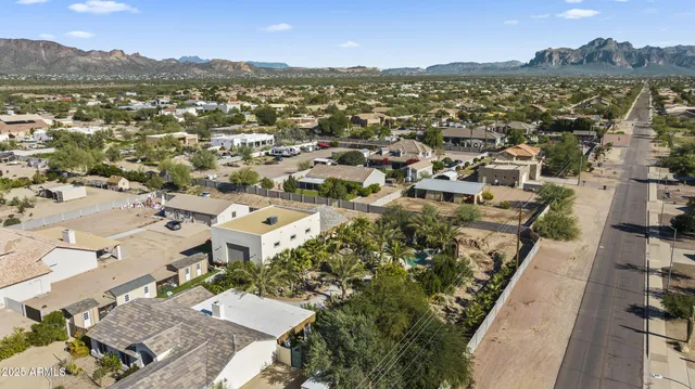 an aerial view of a city with lots of residential buildings and mountain view in back