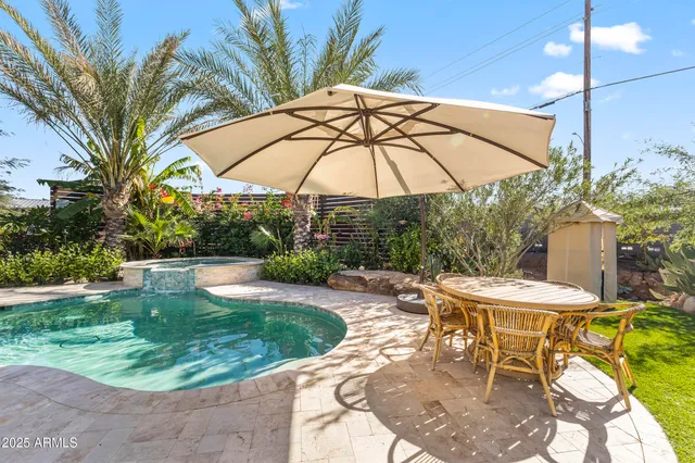 a view of a backyard with table and chairs potted plants and palm tree