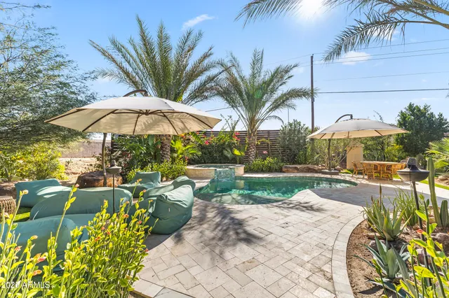 a view of backyard with swimming pool and outdoor seating
