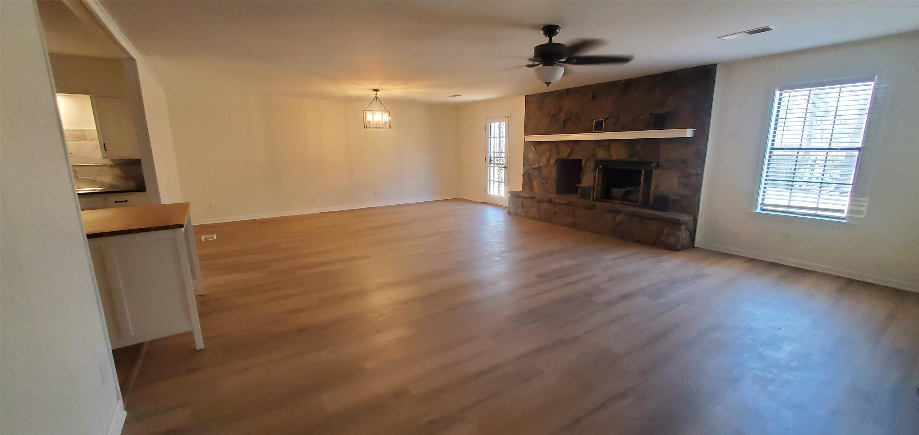 5352 Virgil Road Bartlett, TN 38134 - Photo 8 of 21 an empty room with wooden floor fireplace and windows