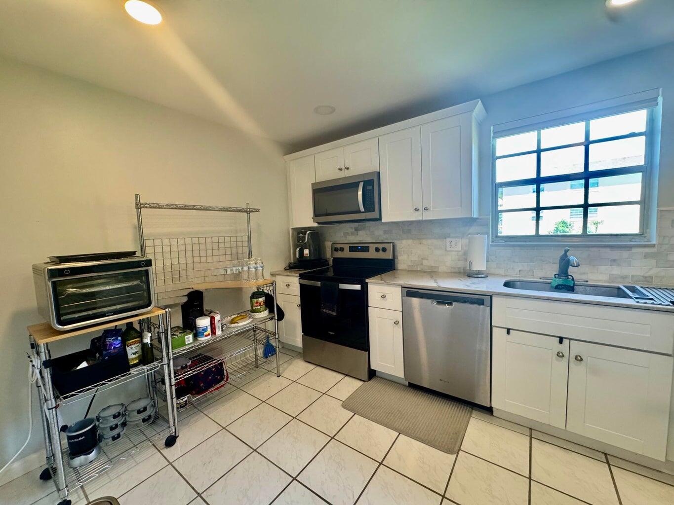 1700 Dover Road, Unit 113A Delray Beach, FL 33445 - Photo 4 of 13 a kitchen with a stove a sink and a microwave
