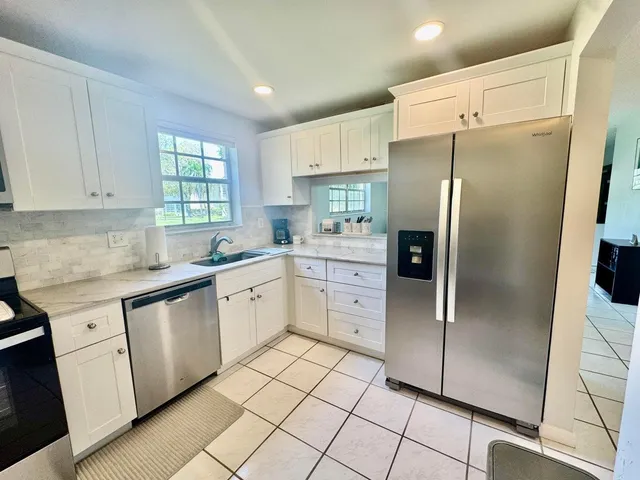 a kitchen with a refrigerator sink and cabinets
