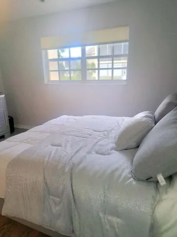 a bedroom with a bed next to a window