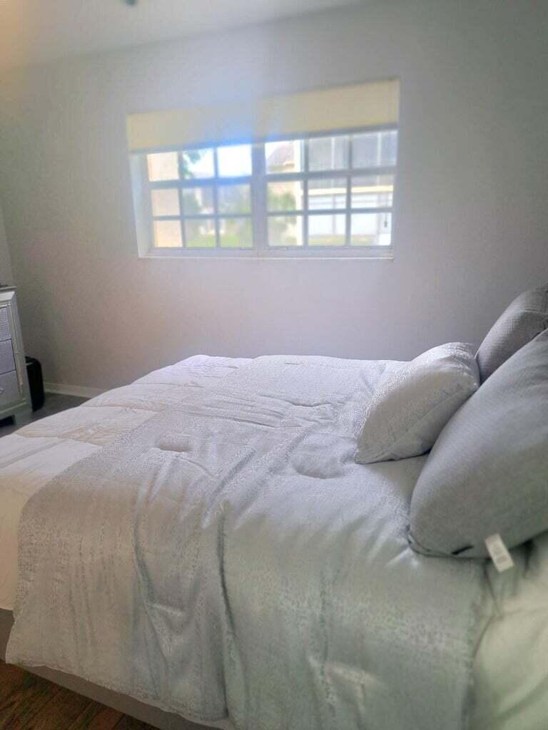 1700 Dover Road, Unit 113A Delray Beach, FL 33445 - Photo 7 of 13 a bedroom with a bed next to a window