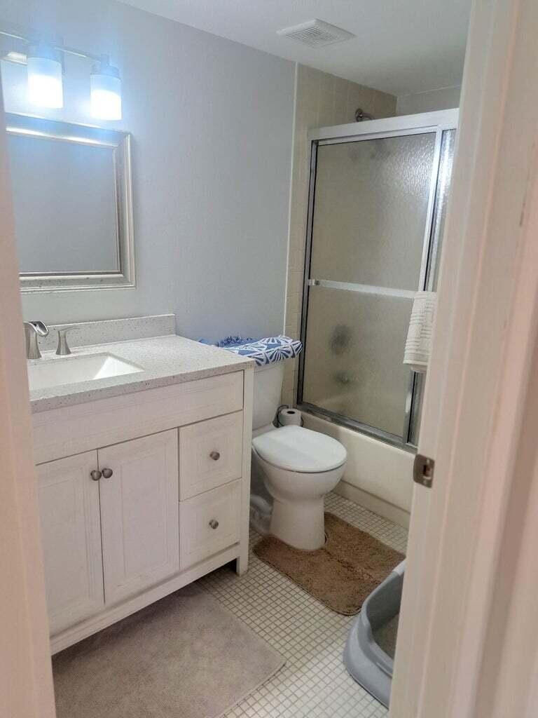 1700 Dover Road, Unit 113A Delray Beach, FL 33445 - Photo 9 of 13 a white toilet sitting next to a bathroom sink